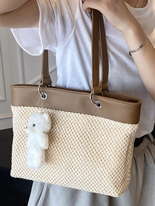 Minimalist straw tote bag with brown leather trim and cute plush bear charm