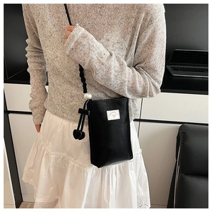 Détail du mini sac bandoulière en cuir PU noir avec bandoulière perle et breloque cœur
