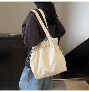 Dettaglio della borsa tote bianco crema con trama a bolle e sistema di chiusura a coulisse