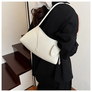 Detail showing white woven pattern and side pocket on a minimalist shoulder bag