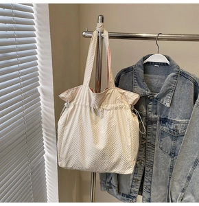 Dettaglio della borsa tote in nylon con tessuto a quadretti bianco sporco e fodera rosa