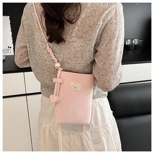 Détail du sac à bandoulière en cuir PU rose avec grande perle et breloques en cœur