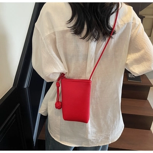 Detailansicht der roten Handytasche aus Leder mit Lychee-Muster und geflochtenem Gurt