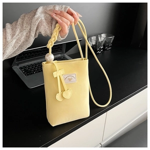 Détail du sac de téléphone jaune en cuir PU avec poignée perle et pendentif cœur