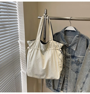 Vista dettagliata della borsa tote color crema in nylon con motivo a scacchi in rilievo