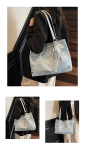 Detail of light blue denim tote with 3D butterfly patches and lace pearl charm