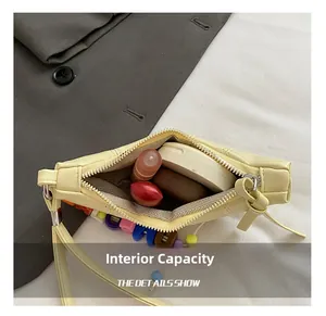 Internal capacity of mini croissant bag showing storage for lipstick and powder compact