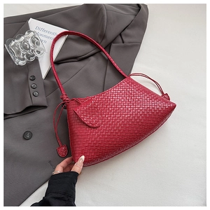 Detail of red woven shoulder bag texture with fringe tassel and leather-like finish