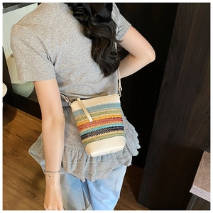 Detail der bunten Regenbogen-Webtasche mit cremefarbenem Lederbesatz an einem Model