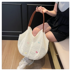 Detail of hollow woven cotton tote bag with colorful mini bows and brown leather straps