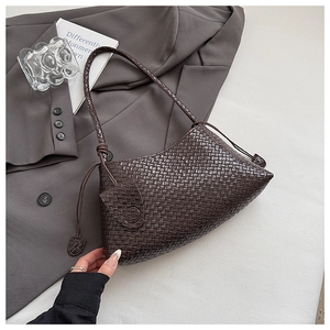 Detailed close-up of dark brown woven leather hobo bag with sleek side drawstring charms