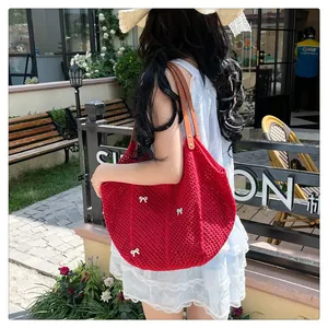 Macro detail of red woven shoulder bag with 3D colorful bows and leather handles