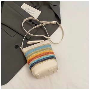 Detail der bunten geflochtenen Stroh-Beuteltasche mit verstellbarem cremefarbenem Riemen