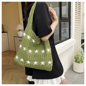 Dettaglio della borsa tote verde in maglia con motivo a stella bianca e texture