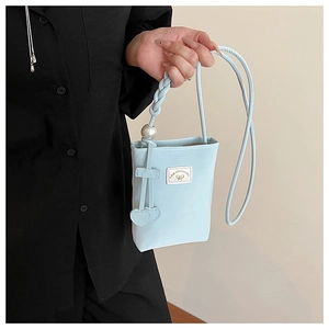 Détail du sac de téléphone bleu clair avec grande perle et pendentifs en cœur