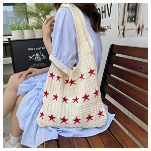 Dettaglio borsa tote all'uncinetto con stelle rosse e trama in maglia