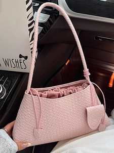 Pink woven baguette bag with drawstring inner pouch and slim braided shoulder strap