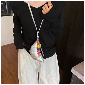 Detailed view of silver croissant bag with metallic finish and rainbow alphabet bead charm
