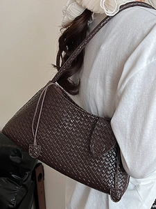 Minimalist dark brown woven underarm bag featuring a refined leather texture and strap