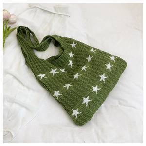 Vista dettagliata della borsa tote in maglia verde con motivi a stelle bianche e texture