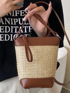 Kontrastreiche Stroh-Eimertasche in Beige mit braunem Lederriemen und Reißverschluss