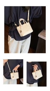 Detail of off-white lychee grain leather crossbody bag with silver heart charm