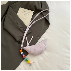 Close-up of purple croissant bag with colorful alphabet beads on grey suit jacket