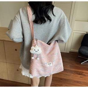 Pink quilted canvas tote bag detail featuring colorful wave embroidery and a cloud charm