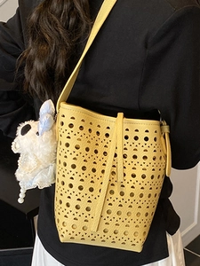 Large capacity yellow hollowed out bucket bag with elegant geometric circular patterns