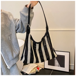 Détail du sac hobo en maille rayée noire et blanche avec bandoulière en cuir réglable