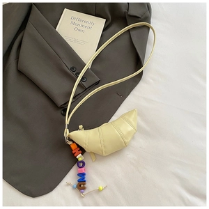 Close-up of mini croissant crossbody bag with colorful letter charm and segment stitching