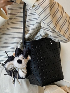 Black hollow-out leather bucket bag with shoulder strap and a cute white puppy pendant