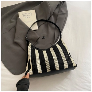 Détail du sac hobo en maille rayée noir et blanc avec bandoulière en similicuir