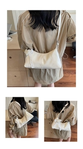 Detail of cream white leather shoulder bag featuring lace bow and pearl decoration