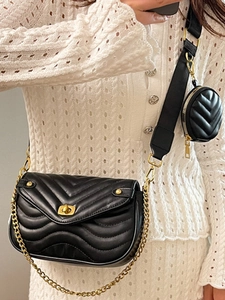 Chic black quilted crossbody bag with golden chain and adjustable strap on a model
