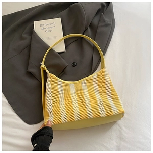 Détail du sac cabas en maille rayée jaune et blanc avec base et bandoulière en cuir lisse