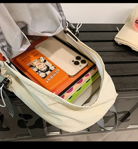 Detail view of the spacious inner compartment of this beige waterproof outdoor backpack