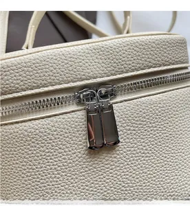 Détail du cuir grainé beige avec double fermeture éclair en métal sur le sac