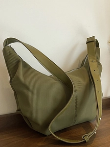 Green pleated nylon crescent bag with adjustable wide strap and minimalist design