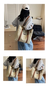 Detail of large canvas tote bag showing side pockets and premium brown leather straps