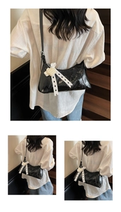 Detail showing shiny black patent leather underarm bag with white lace bow and pearls