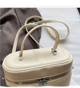 Détail du sac à main en cuir grainé blanc crème avec poignée supérieure et zip en métal