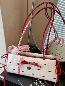 Elegante borsa sottobraccio crema con motivi a fiocco rossi e ciondolo a cuore nello specchio