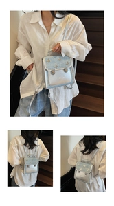 Detail of silver and light blue mini backpack featuring 3D butterfly and glitter finish