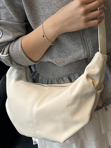 White nylon crescent crossbody bag with pleated texture and adjustable shoulder strap