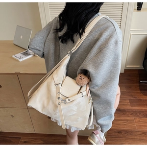 Detailansicht der cremefarbenen PU-Ledertasche mit Silberschnalle und Teddy-Anhänger