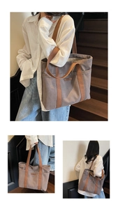 Detail view of large canvas tote bag with brown woven handles and leather patch decoration