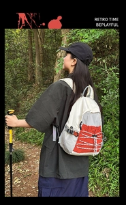 Outdoor backpack detail showing elastic bungee cords and color-block hiking gear design