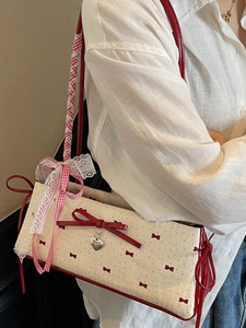 Elegante borsa sottobraccio crema con fiocchi rossi e ciondolo a cuore in pelle