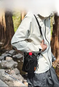 Detail of black nylon drawstring water bottle bag showing a carabiner and side brand label